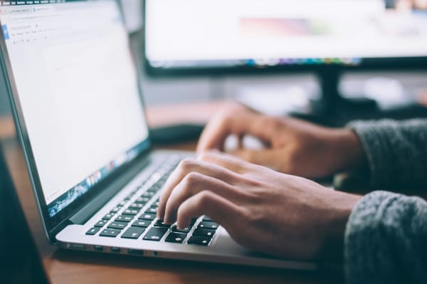 an image of a laptop and a person doing proofreading